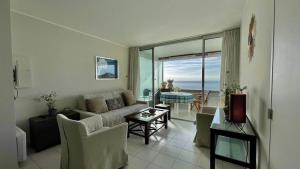 un soggiorno con un divano e un tavolo di LA RESIDENCE COSTA PLANA, Appt 204, VUE SUR LA MER a Cap d'Ail