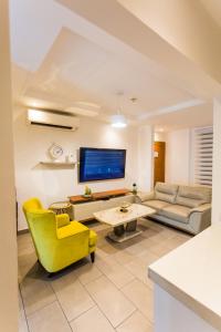 a living room with a yellow chair and a couch at Accra Luxury Apartments at The Edge in Accra