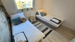 a small room with two beds and a window at RIVERS Apartment in Kołobrzeg