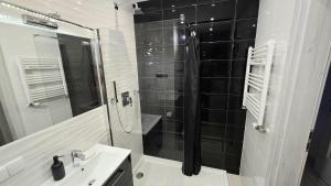 a bathroom with a sink and a glass shower at RIVERS Apartment in Kołobrzeg +7 photos