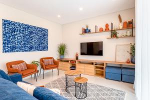 ラゴスにあるAdega luxury Lagos Apartment by Algarve Golden Propertiesの青いソファとテレビのあるリビングルーム