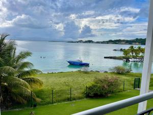a blue boat in a large body of water at Karaibes Residence in Le Gosier