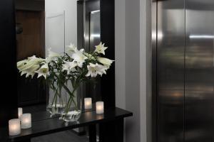 a vase of white flowers and candles on a table at 22 Hill Hotel in Reykjavík