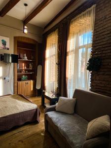 Un dormitorio con una cama y una ventana y un sofá. en OLD Tbilisi ! Старый Тбилиси, en Tiflis 18 fotos más