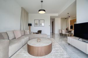 a living room with a couch and a table at Oasis Villa 3 in Khlorakas
