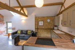 a kitchen and living room with a couch and a table at Mouse House at Tove Valley Cottages in Towcester