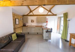 a living room with a couch and a kitchen at Mouse House at Tove Valley Cottages in Towcester +2 photos