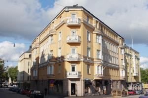 a yellow building with white balconies on a street at Stylish Design Studio Next to The Parliament House in Helsinki