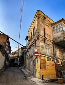 un viejo edificio con una señal de stop delante de él en OLD Tbilisi ! Старый Тбилиси, en Tiflis