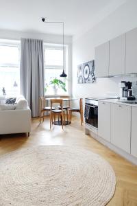 a kitchen and dining room with white cabinets and a table at Stylish Design Studio Next to The Parliament House in Helsinki