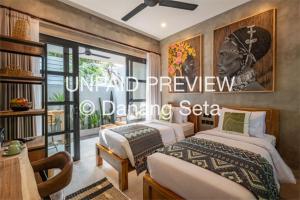 a bedroom with two beds and a window at Lila Nest in Ubud
