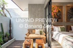 a bedroom with a bed and a table in it at Lila Nest in Ubud