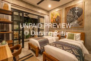 a hotel room with two beds and a table at Lila Nest in Ubud
