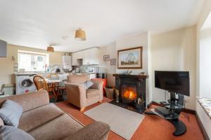 a living room with a couch and a fireplace at Sunny Brow Cottage at Thompson Ground in Hawkshead