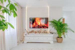 een woonkamer met een tv op een wit dressoir bij Penthouse View Aeroport Iasi 2 in Iaşi +141 foto's