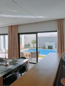 a living room with a table and a swimming pool at VILLA POOL Djerba Aghir AIR CONDITIONING - 5 BEDS in Aghīr