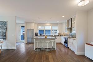 a kitchen with white cabinets and a kitchen island with bar stools at Hillside Haven in Bend