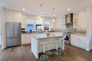 a kitchen with white cabinets and a island with bar stools at Hillside Haven in Bend