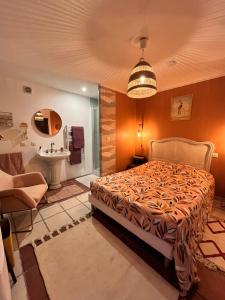 a bedroom with a bed and a bathroom with a sink at Terrama de l'isle in LʼIsle-sur-la-Sorgue