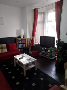 a living room with a red couch and a coffee table at Vance Getaway in Blackpool