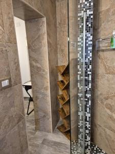 a bathroom with a glass shower with wooden shelves at K-Rooms in Veli Iž +64 photos