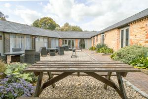 a picnic table in the courtyard of a house at Mouse House at Tove Valley Cottages in Towcester