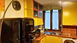 kuchnia z czarną lodówką i zlewem w obiekcie VFH Stylish Boutique Apartment-City Center w Mediolanie