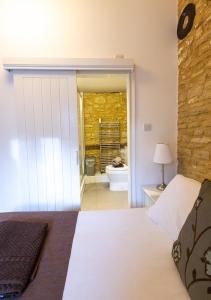 a bedroom with a bed and a bathroom with a toilet at Mouse House at Tove Valley Cottages in Towcester