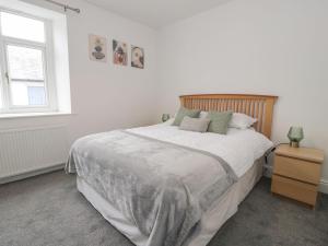 Un dormitorio blanco con una cama grande y una ventana. en 21 Taliesin Street, en Llandudno
