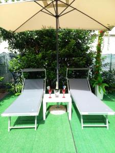 two chairs and a table with an umbrella at Casa Piero in Lecce