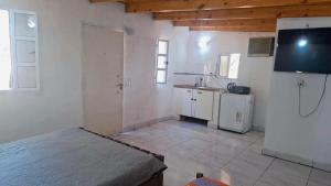 a large white kitchen with a tv on the wall at Hospedaje María Fernanda in Posadas
