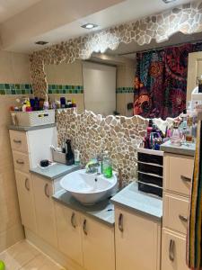 a bathroom with a sink and a mirror at A beautiful tranquil home in Birmingham