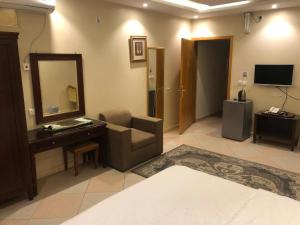 a living room with a chair and a mirror at شقق أروع القصور للشقق المخدومة in Abha