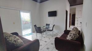 a living room with a couch and a table and chairs at Bairro São José Temporada in Tutóia
