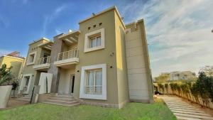 ein großes Haus mit grünem Rasen davor in der Unterkunft Settle Inn Cairo Festival City Villa in Kairo