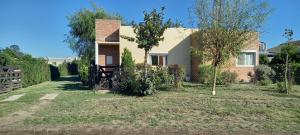 a house with a yard with trees and a fence at Casa Acacias in Sierra de la Ventana