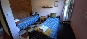 two beds in a room with blue sheets at Casa Acacias in Sierra de la Ventana