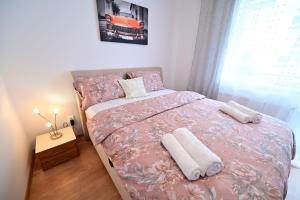 a bedroom with a bed with two towels on it at Alina Sweet Home in Sibiu