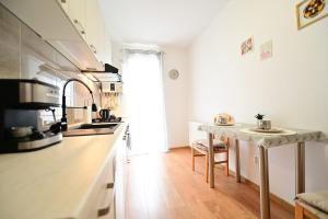 a kitchen with a table in the middle of a room at Alina Sweet Home in Sibiu