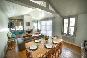 a dining room and living room with a table at Villa Green Oaks in Rivedoux-Plage