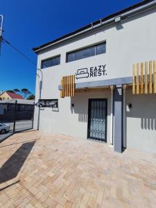 un edificio blanco con un letrero que se lee fácil y fresco en Eazy Rest, en Gqeberha