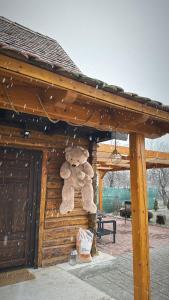 un orsacchiotto appeso sul lato di un edificio di Căsuța cu tihnă a Porumbacu de Sus