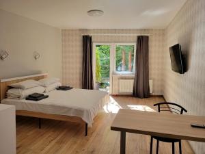 a bedroom with a bed and a table and a window at Glory Apart Hotel in Truskavets +105 photos