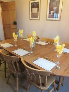 un tavolo in legno con sedie e bicchieri di Allanhead Cottage a Kirkcudbright Altre 13 foto