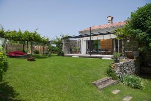 a backyard of a house with a grass yard at Villa Artes with Free Hot Tub & Sauna in Branik