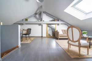 a living room with a vaulted ceiling and a table and chairs at La Suite Vernouillet in Reims