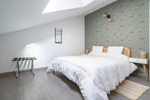 a bedroom with a large white bed and a wall at La Suite Vernouillet in Reims