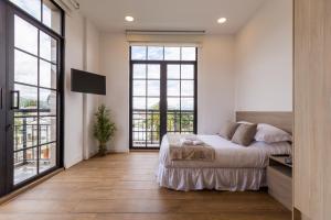 una camera con letto e ampie finestre di Mumbai Corner View Studio a Quito