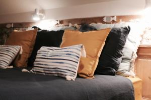 eine Couch mit vielen Kissen drauf in der Unterkunft Duplex accès jacuzzi illimité Z in Villedieu-les-Poëles