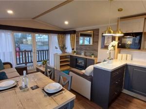 a living room with a dining table and a kitchen at The swift Bordeaux escape Lyons Winkups in Kinmel Bay